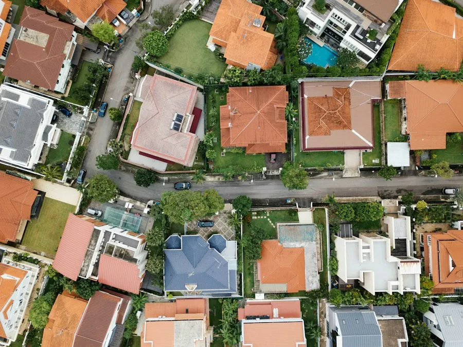 Aerial view of a residential street lined with tile-roofed houses, gardens and trees